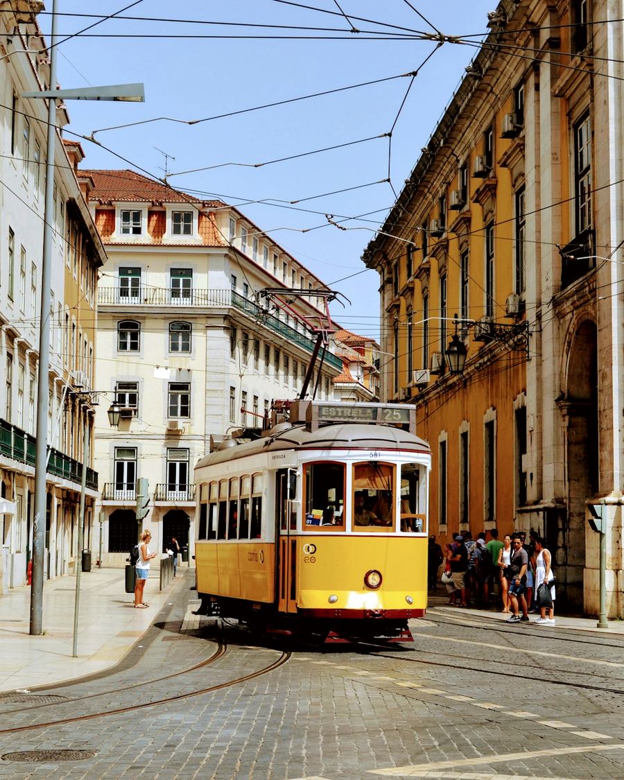 Tranvía amarillo bajando por una calle de Lisboa